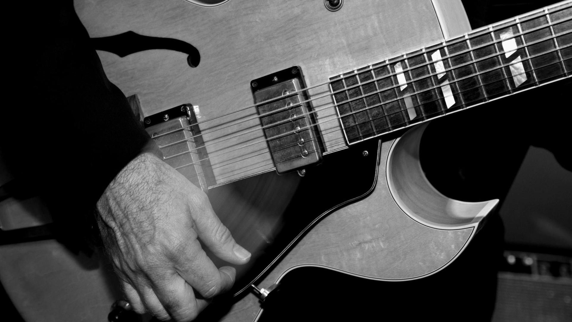 Detail einer Countrygitarre und einer bewegten Hand.