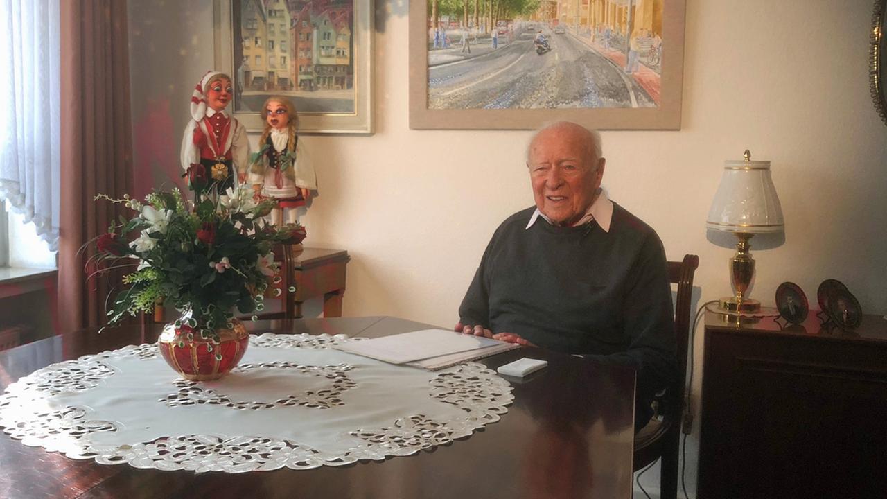 Karl Zieseniß sitzt 2018 an einem dunklen, runden Holztisch im Wohnzimmer seiner Kölner Wohnung Karl Zieseniß sitzt 2018 an einem dunklen, runden Holztisch im Wohnzimmer seiner Kölner Wohnung
