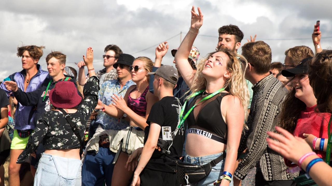 Junge Leute tanzen und hören Musik auf einem Festival. Junge Leute tanzen und hören Musik auf einem Festival.