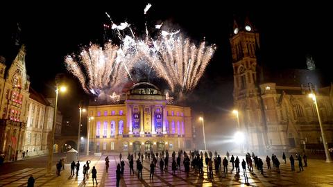 Über dem Opernhaus Chemnitz leuchtet ein farbenfrohes Feuerwerke am nächtlichen Himmel.