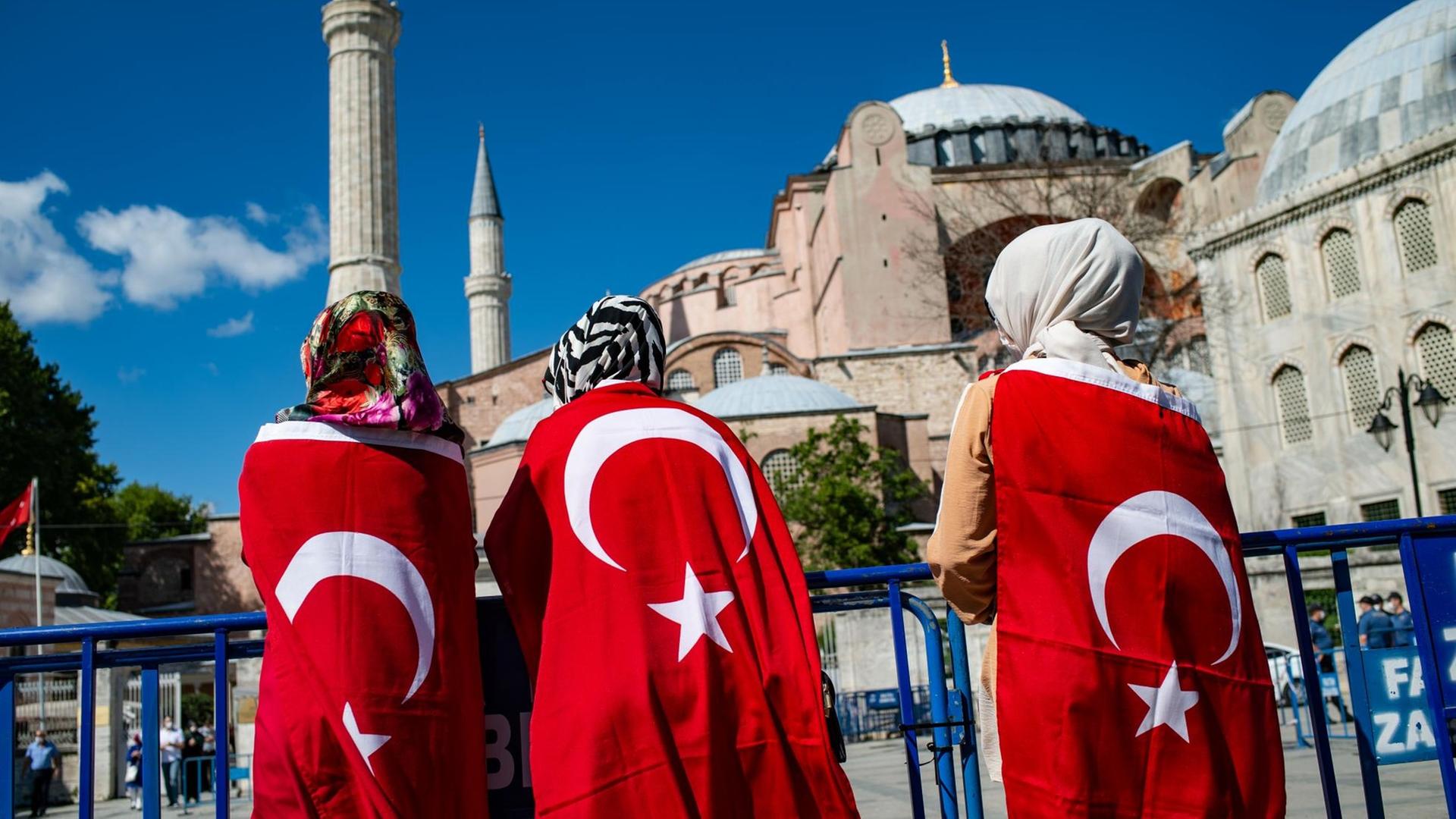 Türkei, Istanbul: Menschen stehen in türkische Nationalflaggen gehüllt vor der Hagia Sophia Türkei, Istanbul: Menschen stehen in türkische Nationalflaggen gehüllt vor der Hagia Sophia
