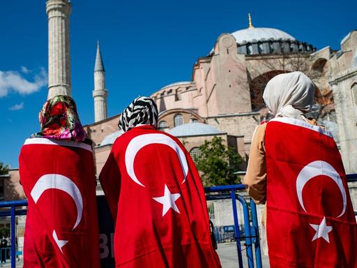Türkei, Istanbul: Menschen stehen in türkische Nationalflaggen gehüllt vor der Hagia Sophia