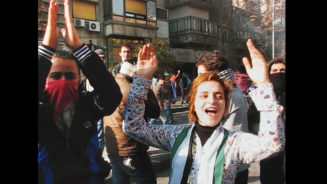 Ausschnitt aus dem Dokumentatfilm "The War Show": Junge Syrer jubeln auf einer Demonstration - Teile der Gesichter von einigen sind mit Tüchern verdeckt Ausschnitt aus dem Dokumentatfilm "The War Show": Junge Syrer jubeln auf einer Demonstration - Teile der Gesichter von einigen sind mit Tüchern verdeckt