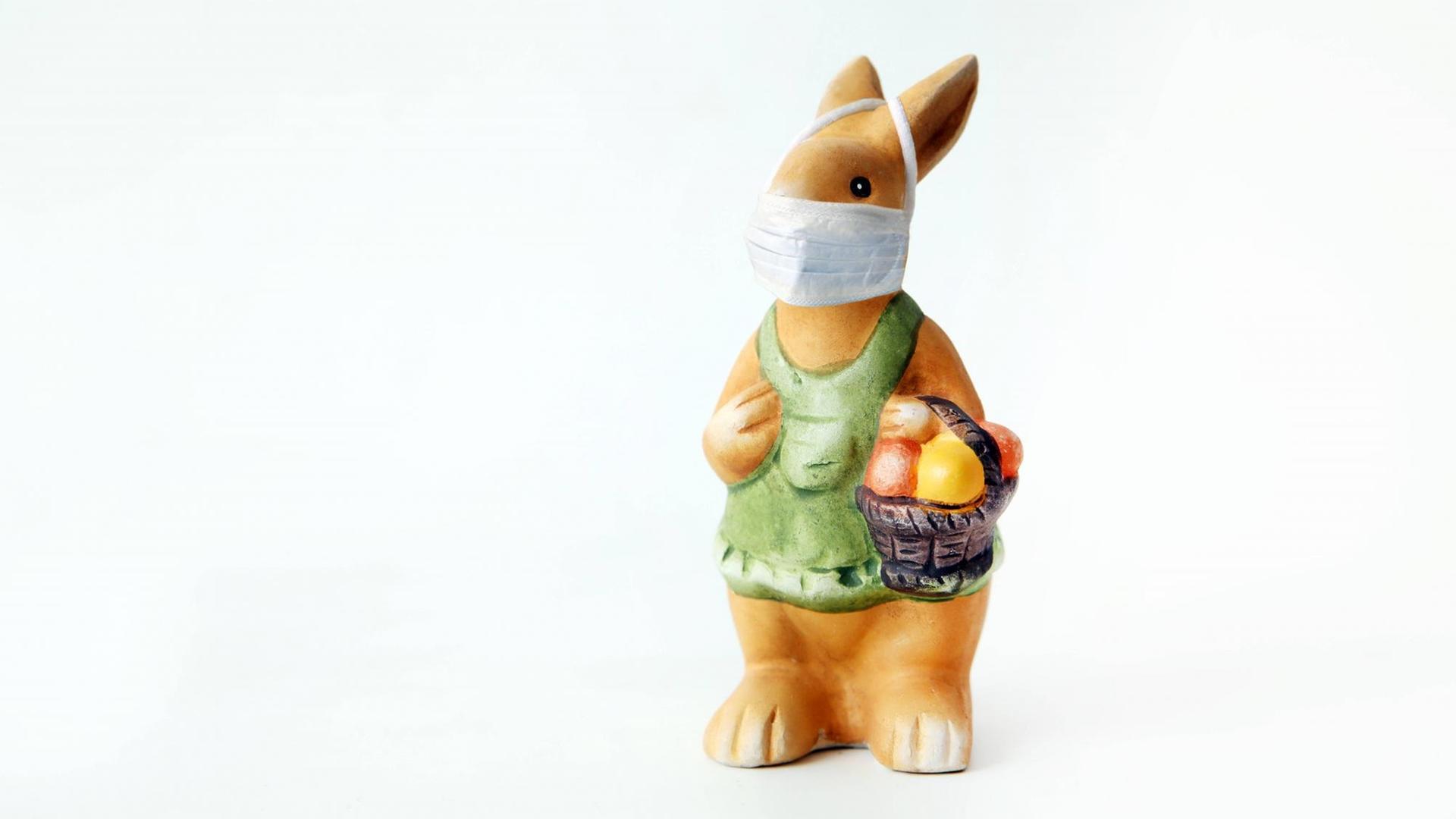 Eine Oster-Hasen-Figur trägt einen Mund-Schutz.