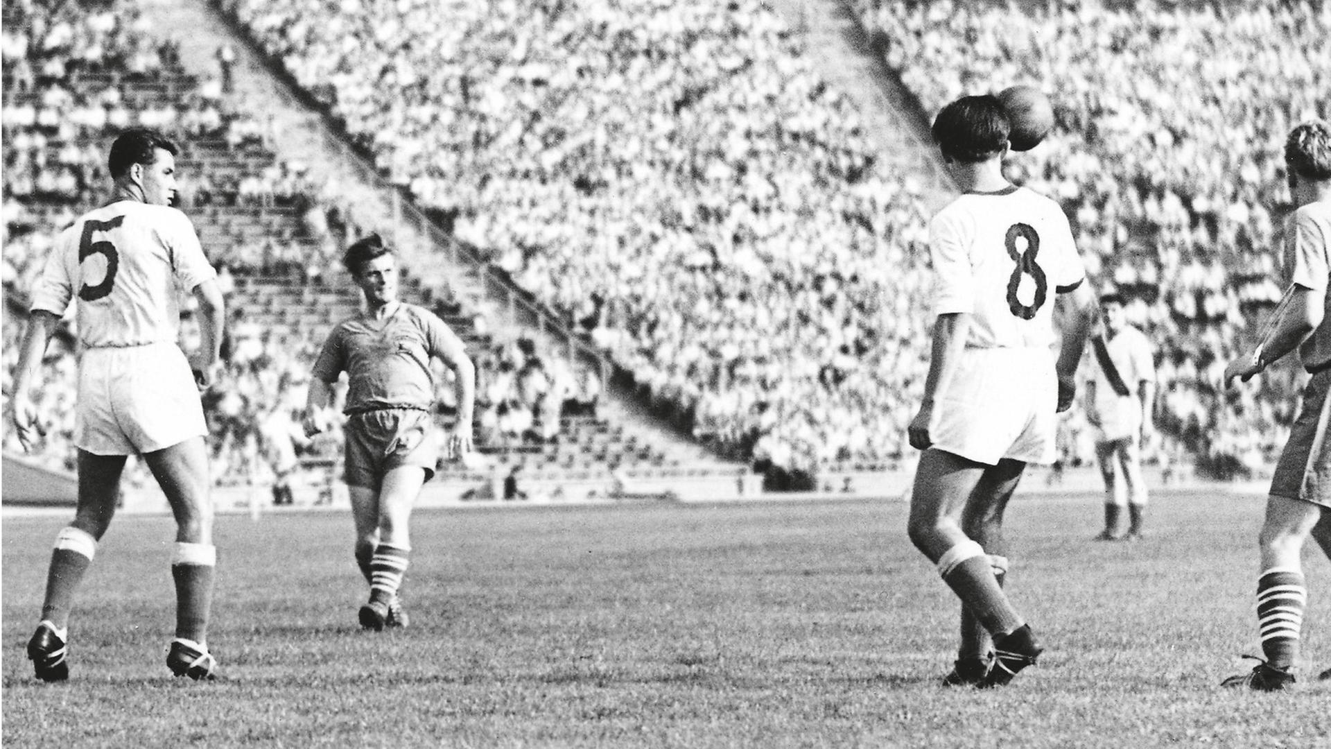 Mehrere Fußballspieler stehen auf dem Platz des Leipziger Zentralstadions vor vollen Rängern. Mehrere Fußballspieler stehen auf dem Platz des Leipziger Zentralstadions vor vollen Rängern.