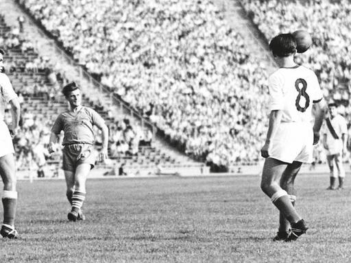 Mehrere Fußballspieler stehen auf dem Platz des Leipziger Zentralstadions vor vollen Rängern.