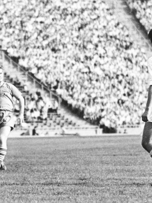 Mehrere Fußballspieler stehen auf dem Platz des Leipziger Zentralstadions vor vollen Rängern.