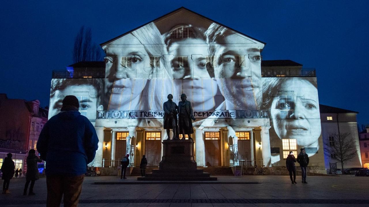 Besucher vor dem Deutschen Nationaltheater Weimar zur Eröffnung der Woche der Demokratie. Gesichter verschiedener Menschen werden auf das Gebäude projiziert. Besucher vor dem Deutschen Nationaltheater Weimar zur Eröffnung der Woche der Demokratie. Gesichter verschiedener Menschen werden auf das Gebäude projiziert.