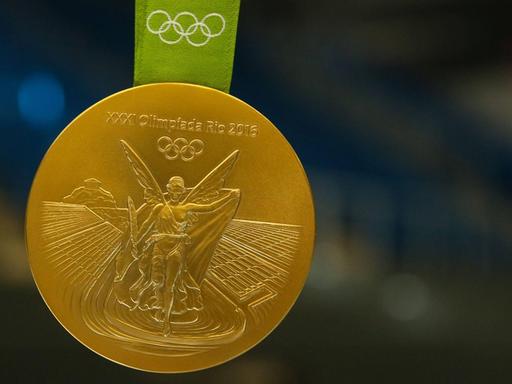 Michael Damgaard (SC Magdeburg) zeigt seine olympische Goldmedaille von Rio.