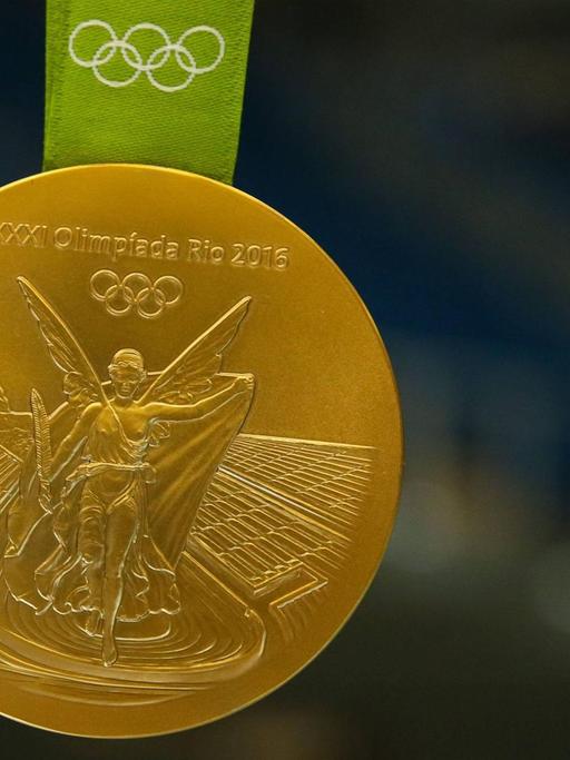 Michael Damgaard (SC Magdeburg) zeigt seine olympische Goldmedaille von Rio.