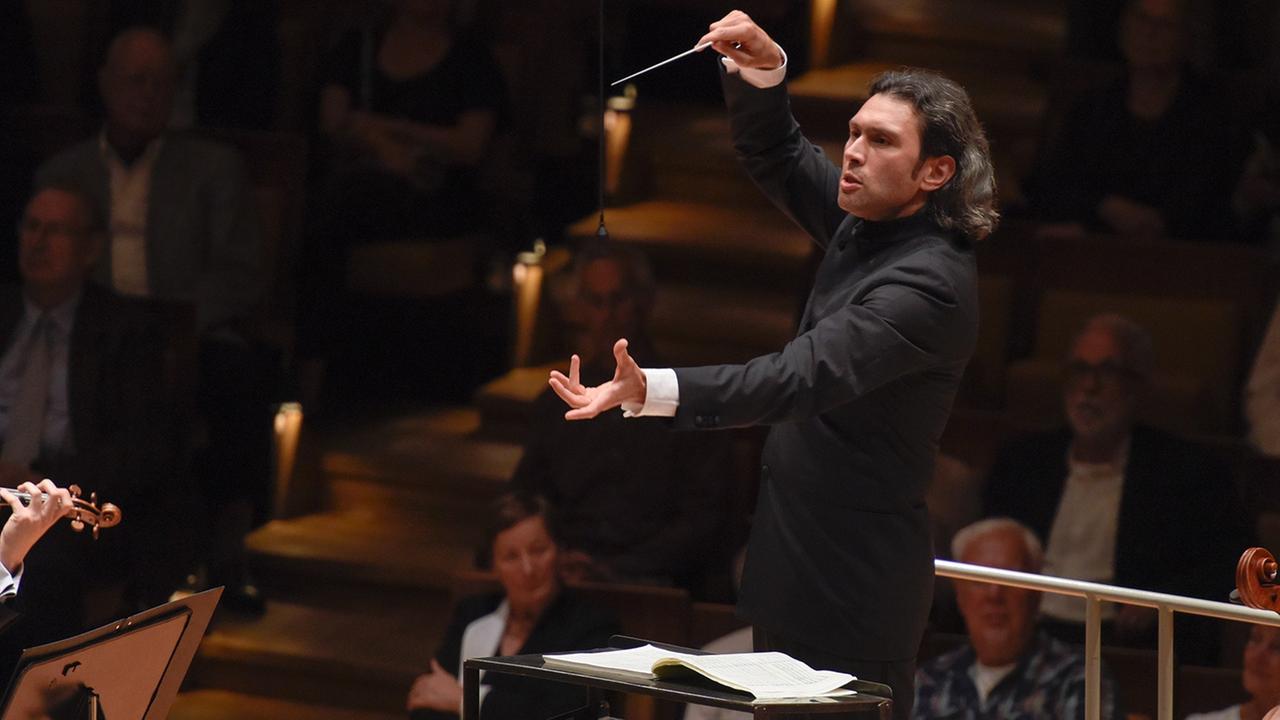 Der Dirigent Vladimir Jurowski dirigiert das RSB mit Publikum im Hintergrund Der Dirigent Vladimir Jurowski dirigiert das RSB mit Publikum im Hintergrund