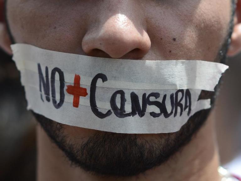 "No + censura" (keine Zensur mehr) hat sich ein Demonstrant in Caracas auf den Mund geklebt.