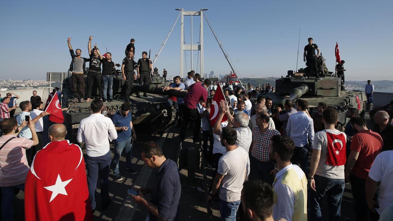 Menschen in Istanbul stehen um und auf Panzern des türkischen Militärs. Im Hintergrund die Bosporus-Brücke. Menschen in Istanbul stehen um und auf Panzern des türkischen Militärs. Im Hintergrund die Bosporus-Brücke.