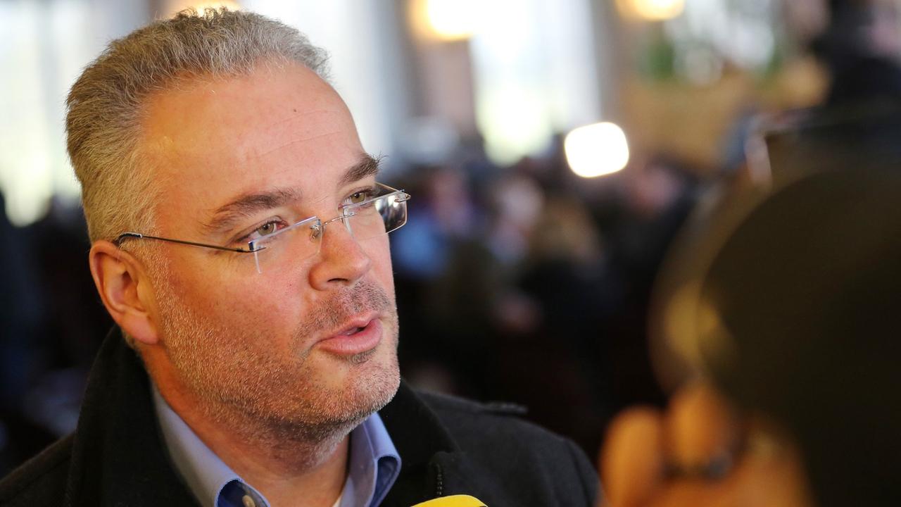 Nierth spricht mit grauen Haaren und Brille in ein Mikrofon. Nierth spricht mit grauen Haaren und Brille in ein Mikrofon.