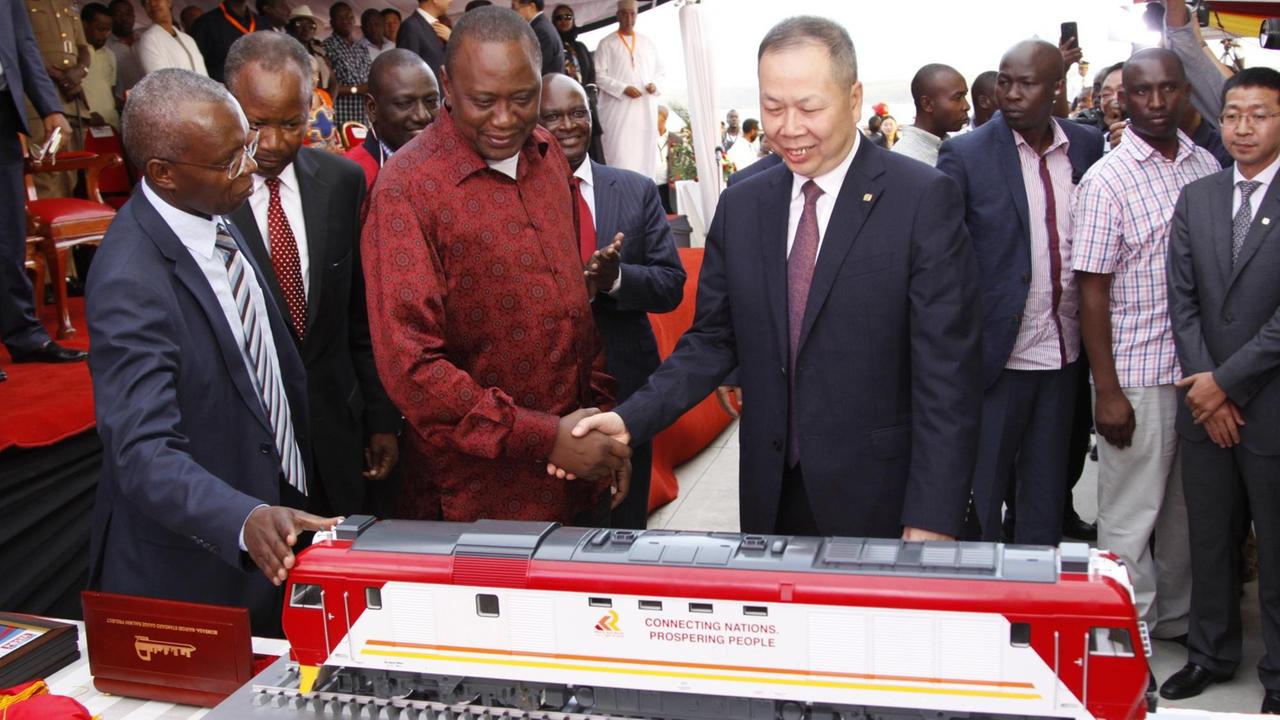Der kenianische Präsident Uhuru Kenyatta (2.v.l) und der Präsident der China Communications Contruction Company, Chen Fenjian (M), bei der Eröffnung einer neuen Bahnstrecke, die die Hafenstadt Mombasa mit der Hauptstadt Nairobi verbindet Der kenianische Präsident Uhuru Kenyatta (2.v.l) und der Präsident der China Communications Contruction Company, Chen Fenjian (M), bei der Eröffnung einer neuen Bahnstrecke, die die Hafenstadt Mombasa mit der Hauptstadt Nairobi verbindet