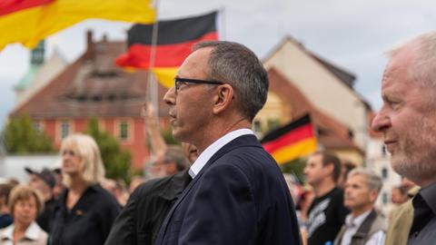 Das Foto zeigt Jörg Urban, Spitzenkandidat der AfD in Sachsen, vor Deutschland-Fahnen.