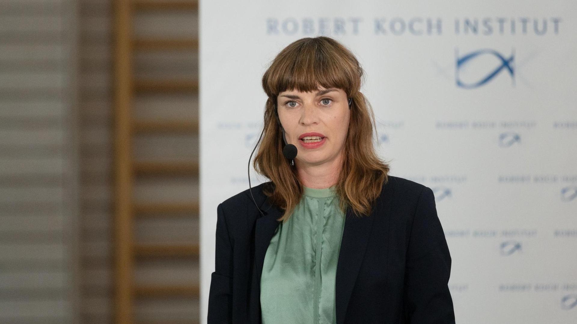 Claudia Santos-Hövener am Rednerpult, in Hintergrund eine Tafel mit der Aufschrift des Robert Koch-Instituts Claudia Santos-Hövener am Rednerpult, in Hintergrund eine Tafel mit der Aufschrift des Robert Koch-Instituts