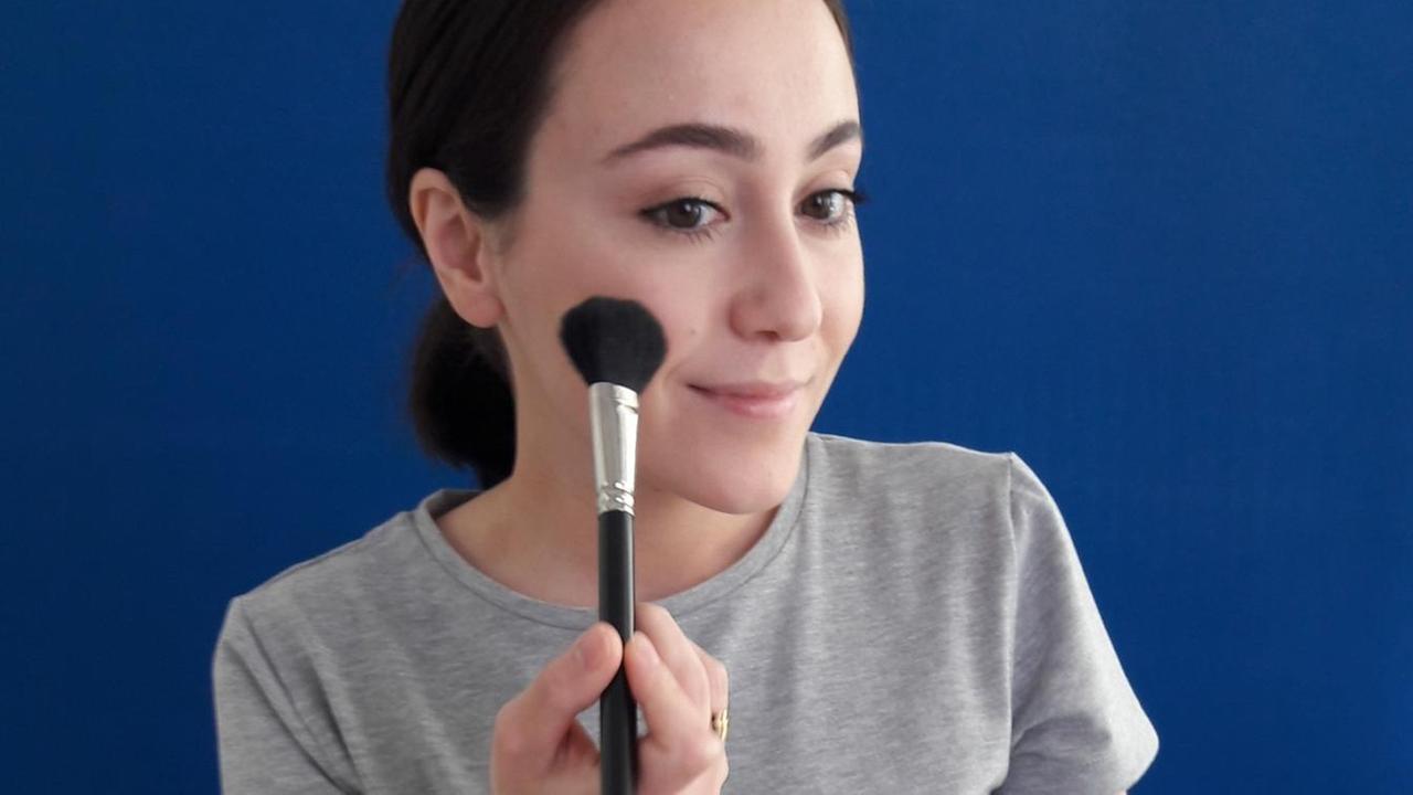 Das Bild zeigt die Youtuberin Hatice Schmidt, die sich mit einem Pinsel schminkt. Das Bild zeigt die Youtuberin Hatice Schmidt, die sich mit einem Pinsel schminkt.