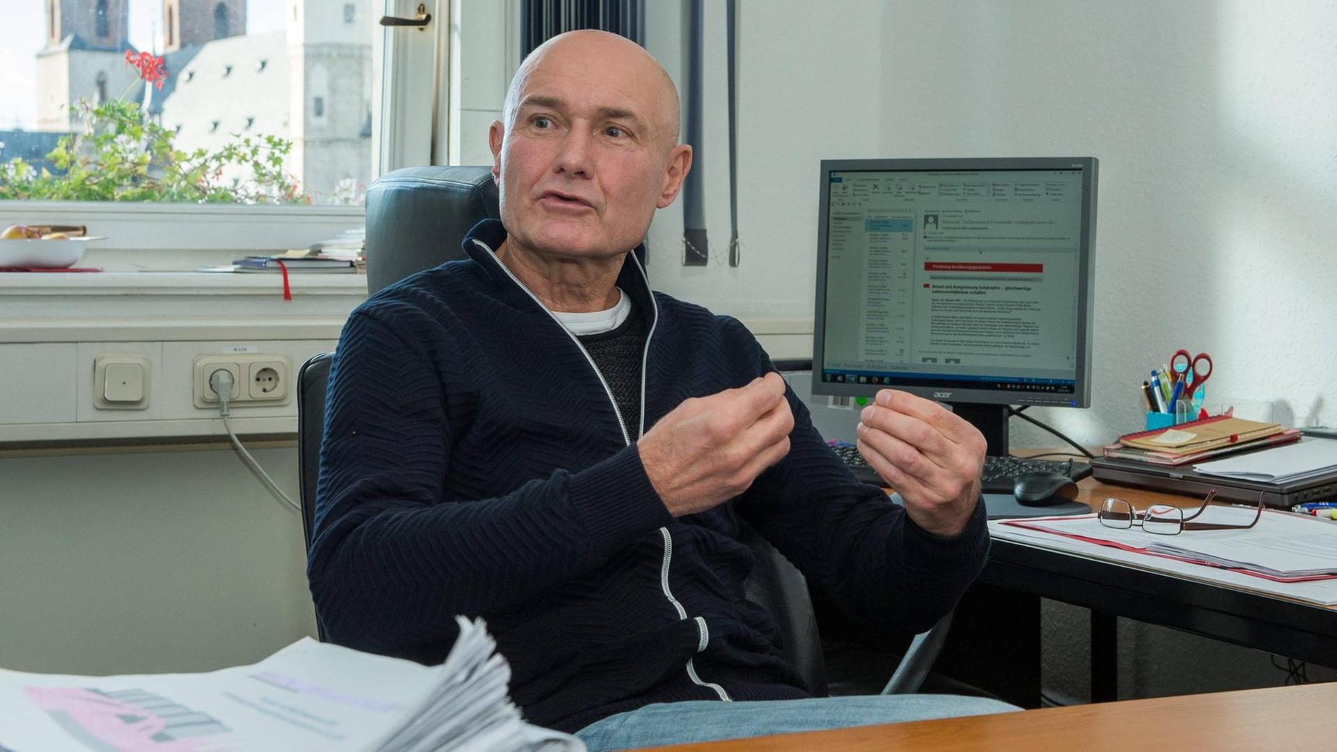 Lothar Rochau sitzt an einem Eckschreibtisch und gestikuliert während er spricht. Lothar Rochau sitzt an einem Eckschreibtisch und gestikuliert während er spricht.