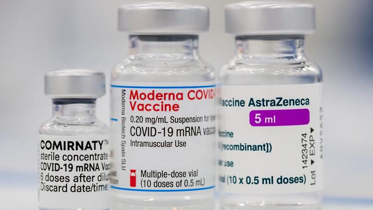 Jeweils ein Fläschchen der Corona-Impfstoffe von Pfizer-BioNTech, Moderna und AstraZeneca stehen auf einem Tisch.