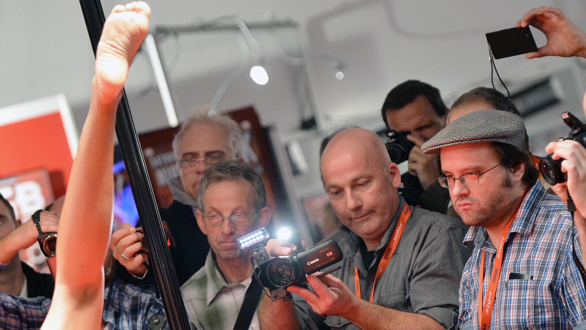 Besucher filmen und fotografieren während der Erotik-Messe "Venus" 2013 in Berlin die Vorführungen einer Frau. Besucher filmen und fotografieren während der Erotik-Messe "Venus" 2013 in Berlin die Vorführungen einer Frau.