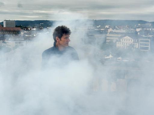 Künstler Daniel Knorr steht auf dem Zwehrenturm in Kassel (Hessen) im Rauch seiner Installation "Expiration Movement".