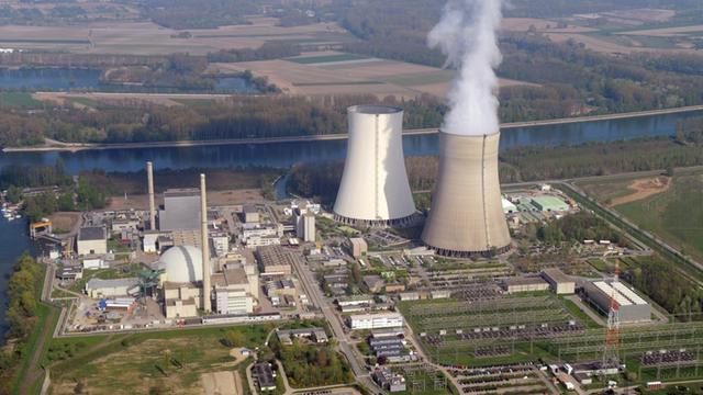 Das Atom-Kraft-Werk steht an einem Fluß. Es hat 2 große Kühl-Türme. 