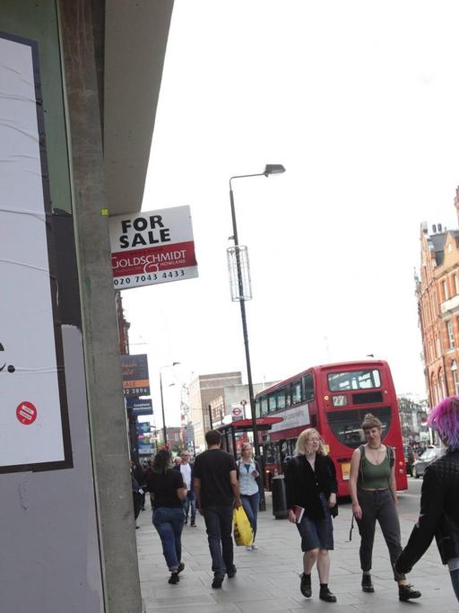 Eines der Plakate von Jeremy Deller - strong and stable my arse - Londoner Bürger gehen daran vorbei. (Bild: imago stock&people / Yui Mok / PA Wire General Election 2017)