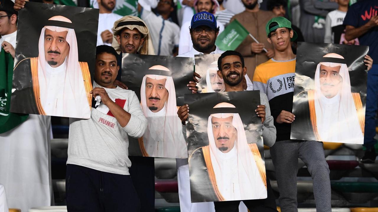 Saudi-arabische Fußball Fans mit Plakaten von König Salman ibn Abd al-Aziz beim Spiel gegen Katar Saudi-arabische Fußball Fans mit Plakaten von König Salman ibn Abd al-Aziz beim Spiel gegen Katar