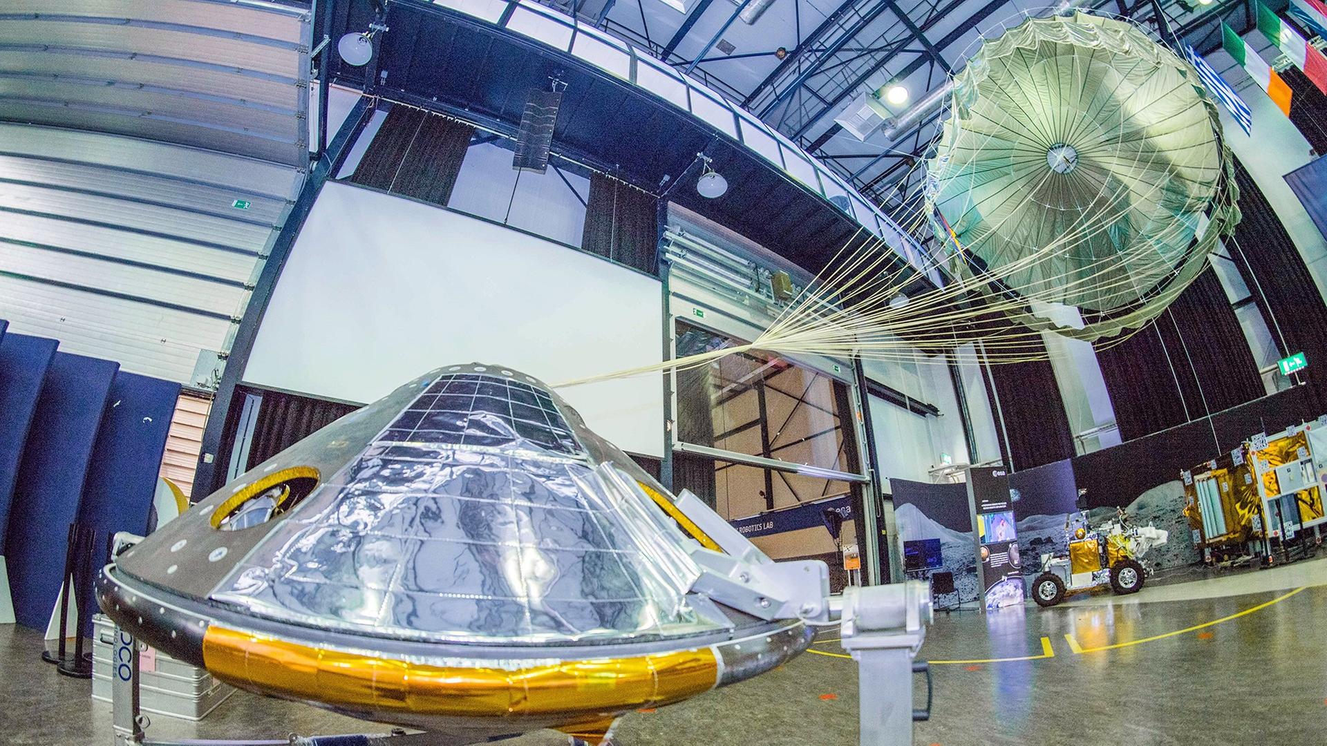 Ein Modell des Exomars-Landegeräts Schiaparelli mit Fallschirm in Originalgröße im Technologiezentrum der ESA in Noordwijk in den Niederlanden Ein Modell des Exomars-Landegeräts Schiaparelli mit Fallschirm in Originalgröße im Technologiezentrum der ESA in Noordwijk in den Niederlanden