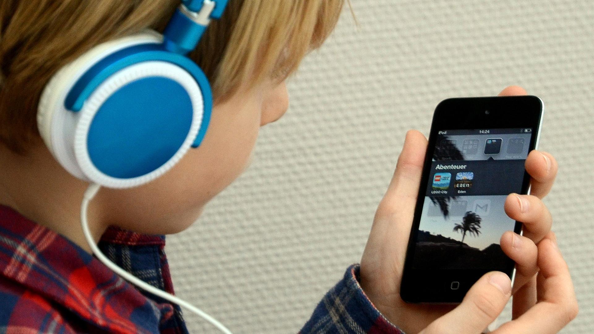 Ein Kind hört Musik mit seinem iPod von Apple. Ein Kind hört Musik mit seinem iPod von Apple.