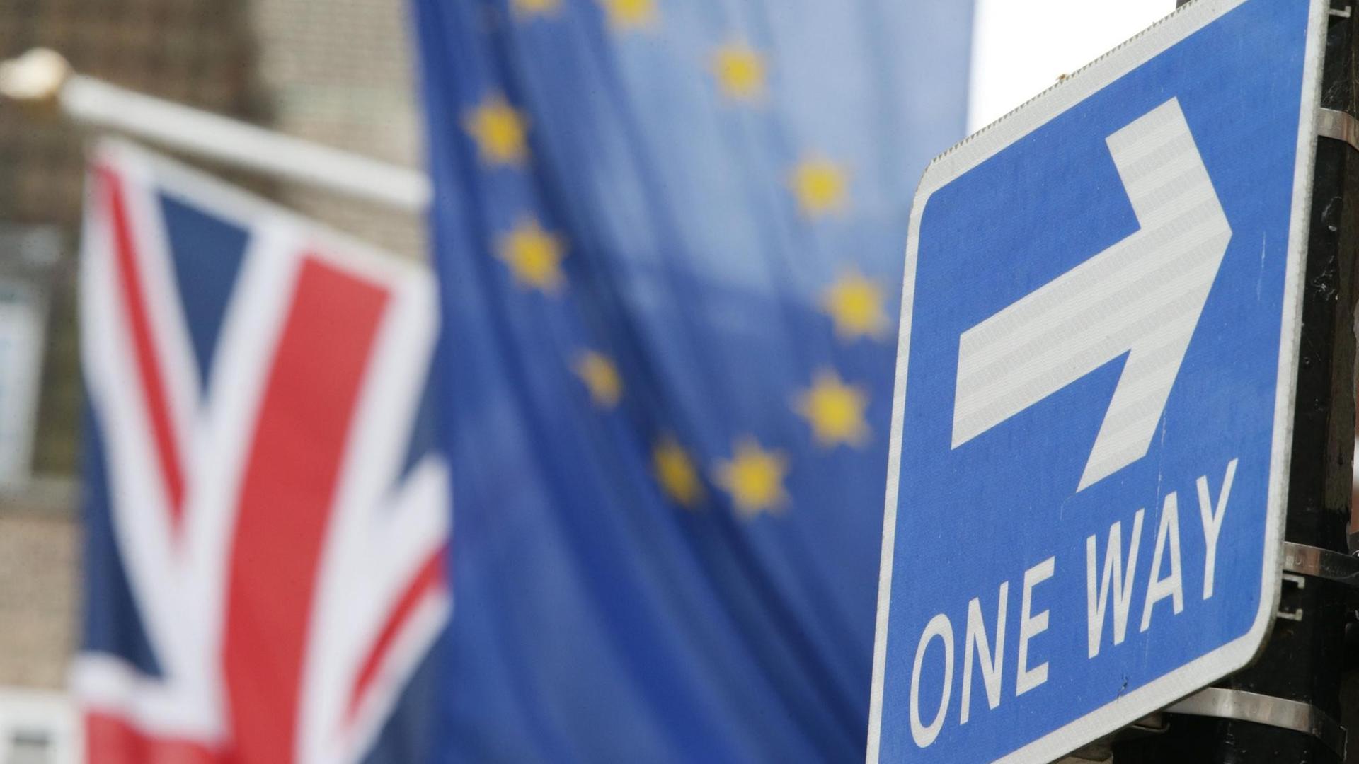 Ein englisches Einbahnstraße-Schild, im Hintergrund sind die Europaflagge und ein Union-Jack zu sehen. Ein englisches Einbahnstraße-Schild, im Hintergrund sind die Europaflagge und ein Union-Jack zu sehen.