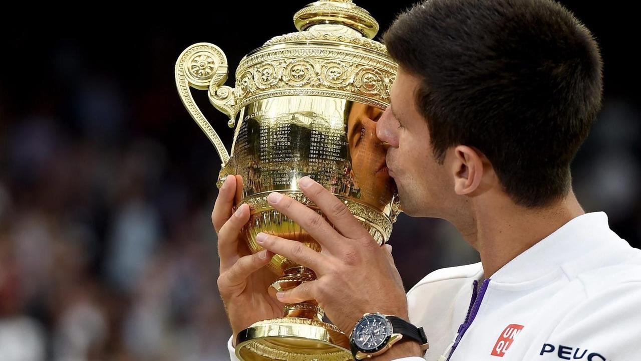 Novac Djokovic küsst den Pokal von Wimbledon.