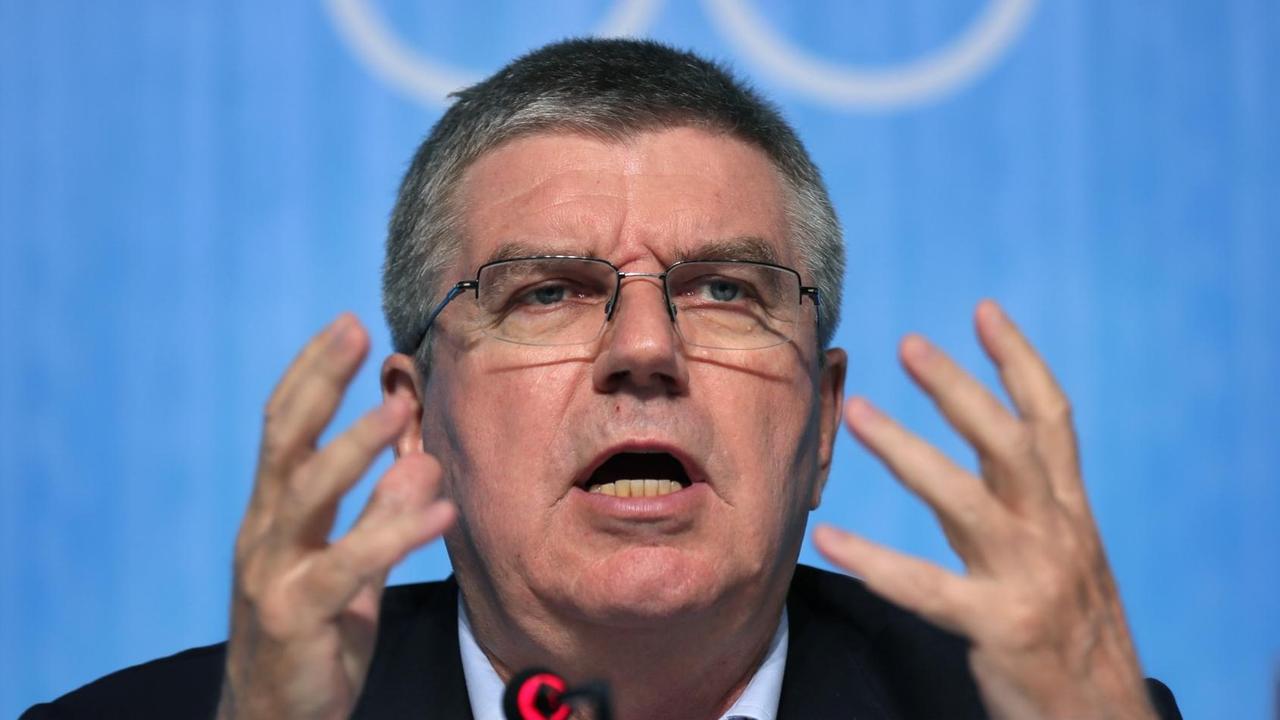 Sie sehen IOC-Präsident Bach, er gestikuliert mit den Händen.