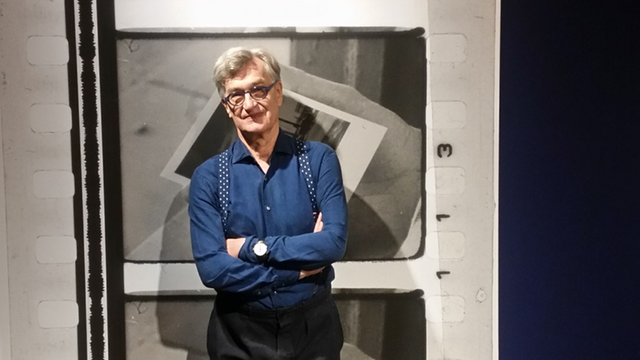 Wim Wenders steht vor großformatigen Polaroidabzügen