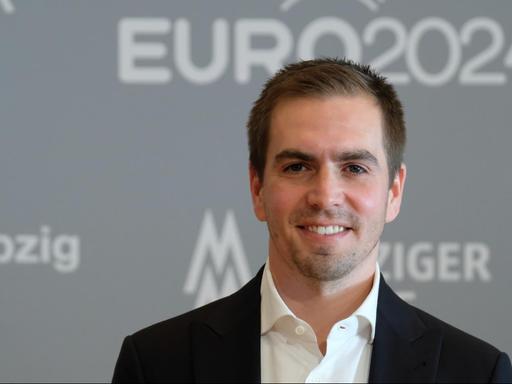 Der ehemalige Fußball-Nationalspieler Philipp Lahm lächelt in die Kamera, im Hintergrund das Logo der EURO 2024