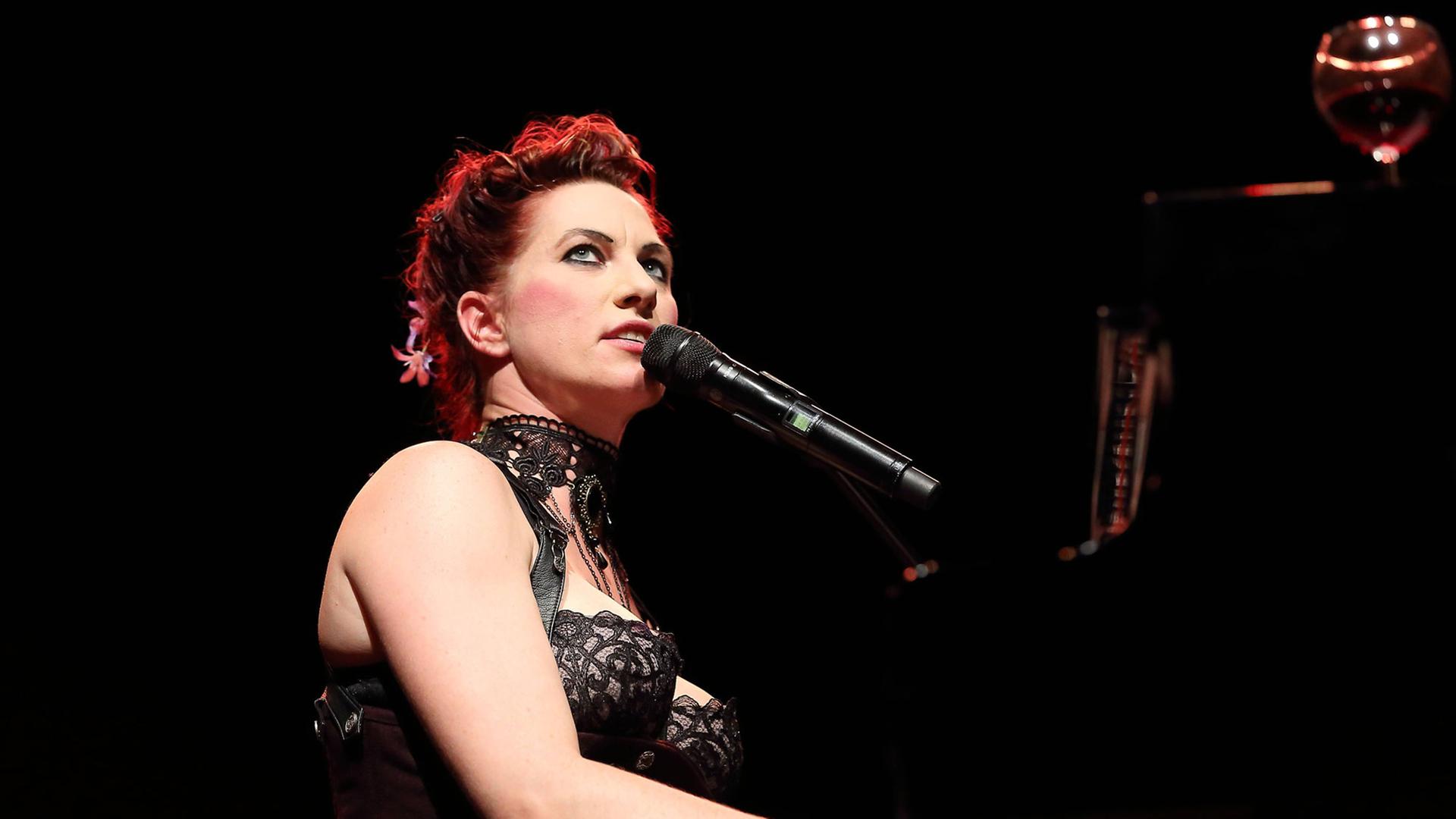 Bei einem Konzert in Berlin sitzt Amanda Palmer am Flügel und singt.