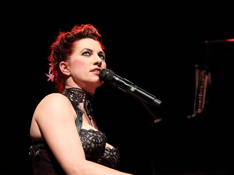 Bei einem Konzert in Berlin sitzt Amanda Palmer am Flügel und singt.