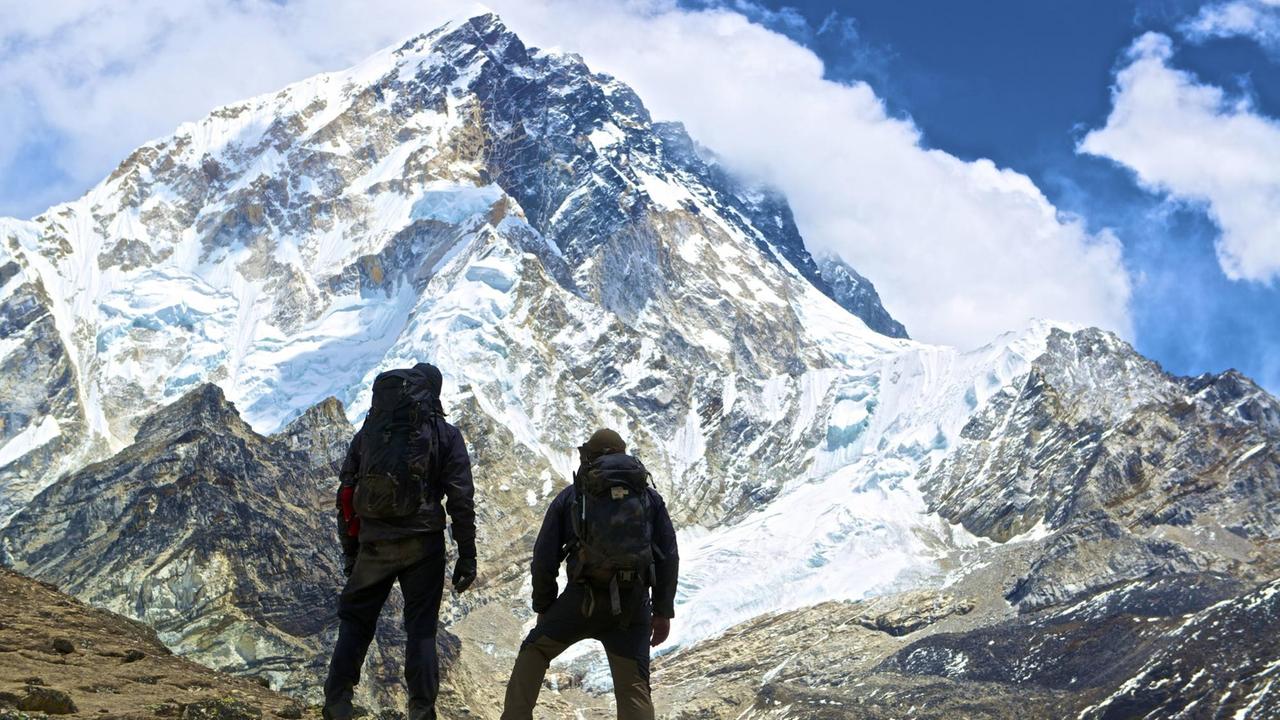 Zwei Bergsteiger blicken auf den Ama Dablam im Himalaya. Zwei Bergsteiger blicken auf den Ama Dablam im Himalaya.