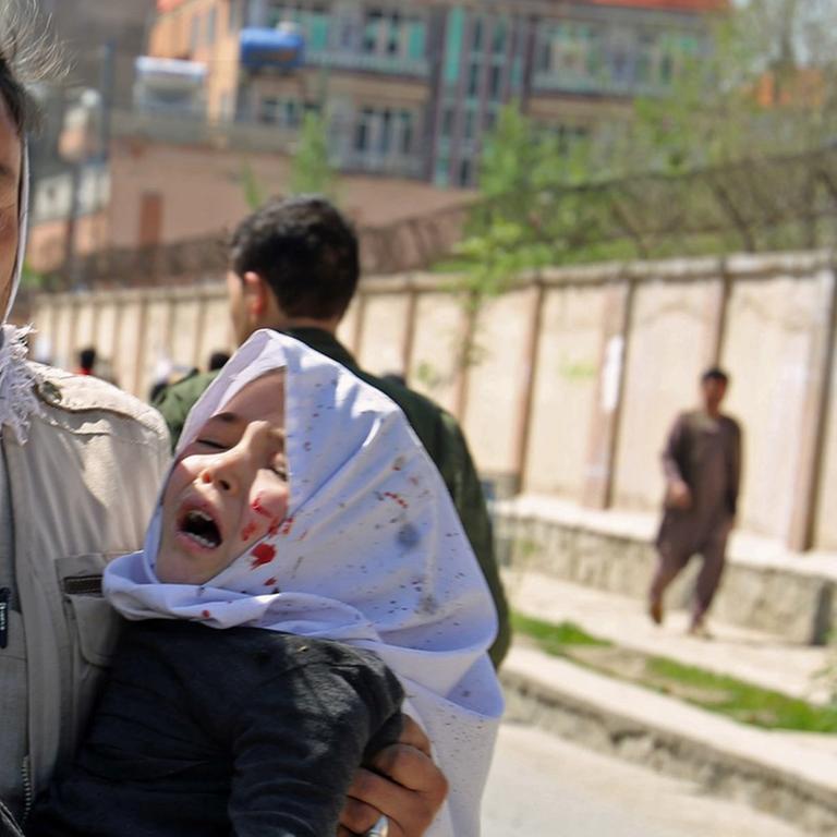 Ein Mann trägt am 22.4.2018 in der afghanischen Hauptstadt Kabul ein bei einem Selbstmordanschlag verwundetes Kind.