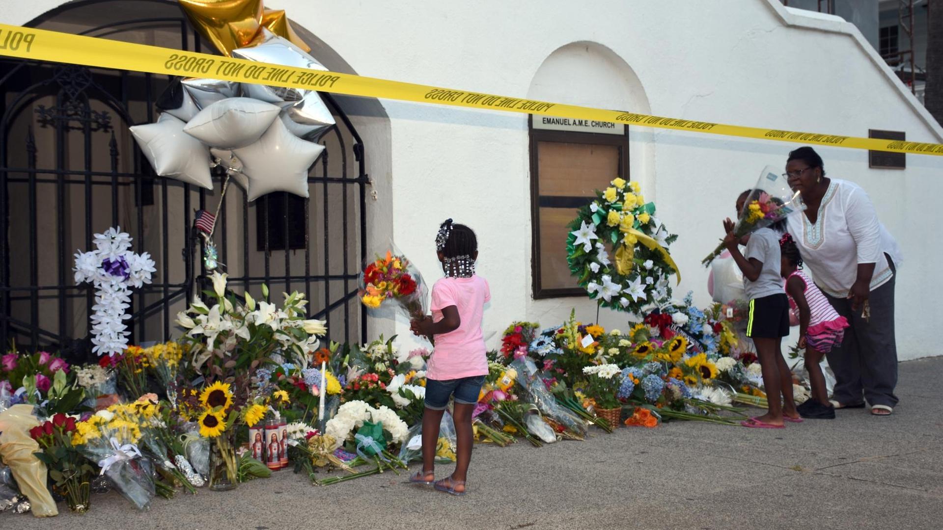 Menschen legen nach den Morden in Charleston in den USA Blumen vor der Kirche ab Menschen legen nach den Morden in Charleston in den USA Blumen vor der Kirche ab