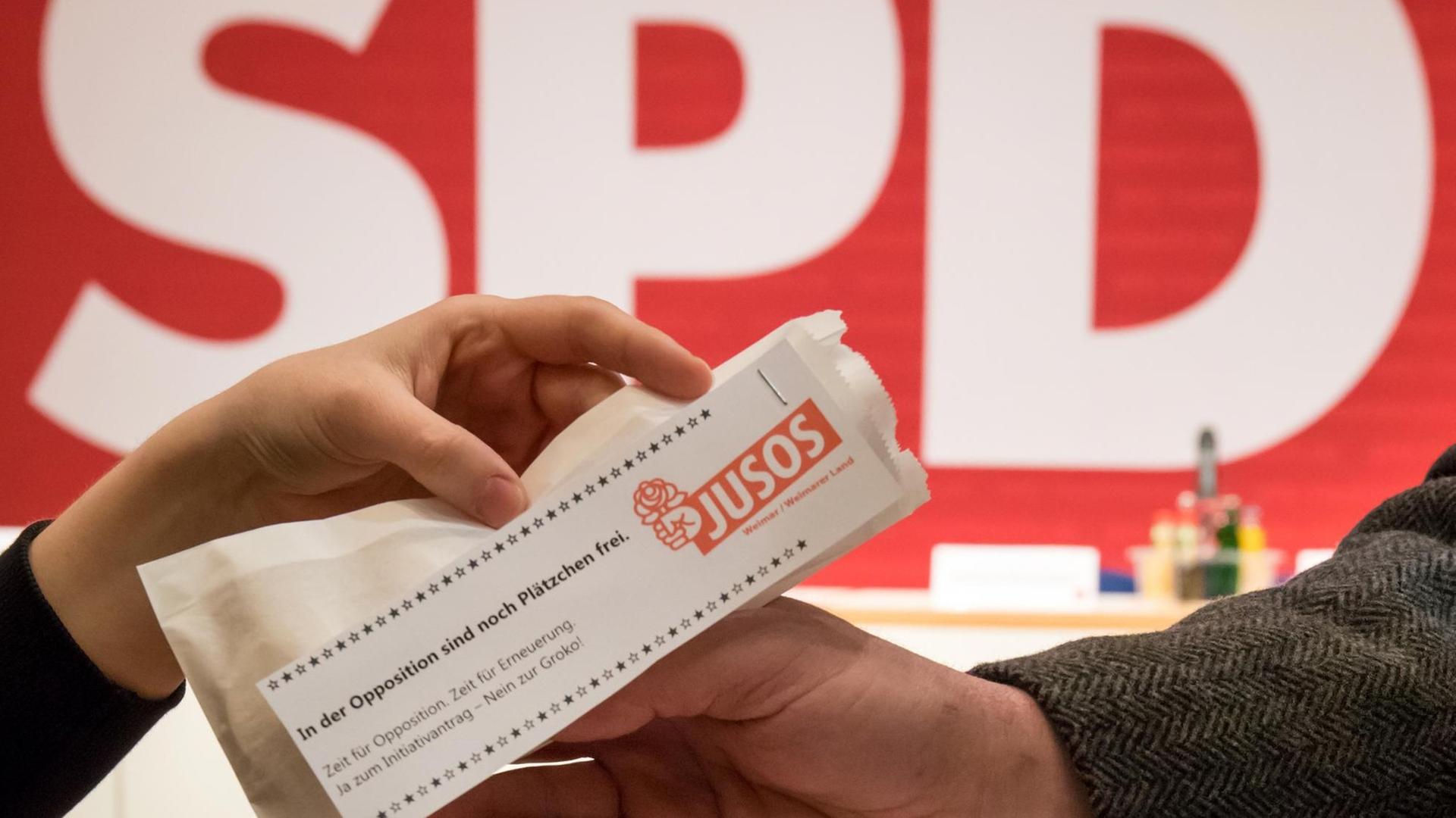 Ein Juso-Mitglied verteilt am 16.12.2017 beim außerordentlichen Landesparteitag der SPD Thüringen in Erfurt (Thüringen) eine Plätzchentüte mit Werbung für den Gang in die Opposition. Ein Juso-Mitglied verteilt am 16.12.2017 beim außerordentlichen Landesparteitag der SPD Thüringen in Erfurt (Thüringen) eine Plätzchentüte mit Werbung für den Gang in die Opposition.