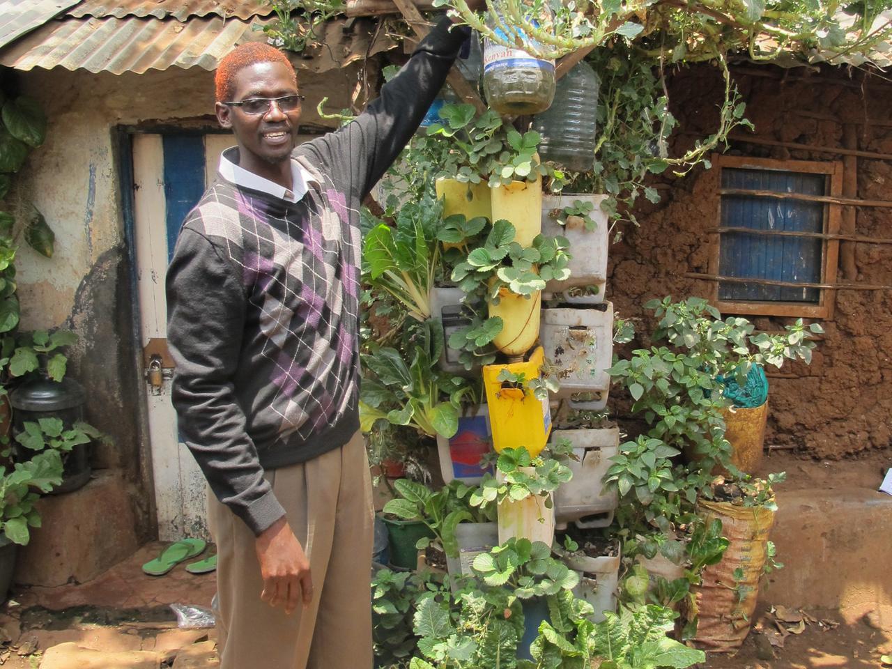 Musa Juma Musa steht neben seiner Sackpflanze.