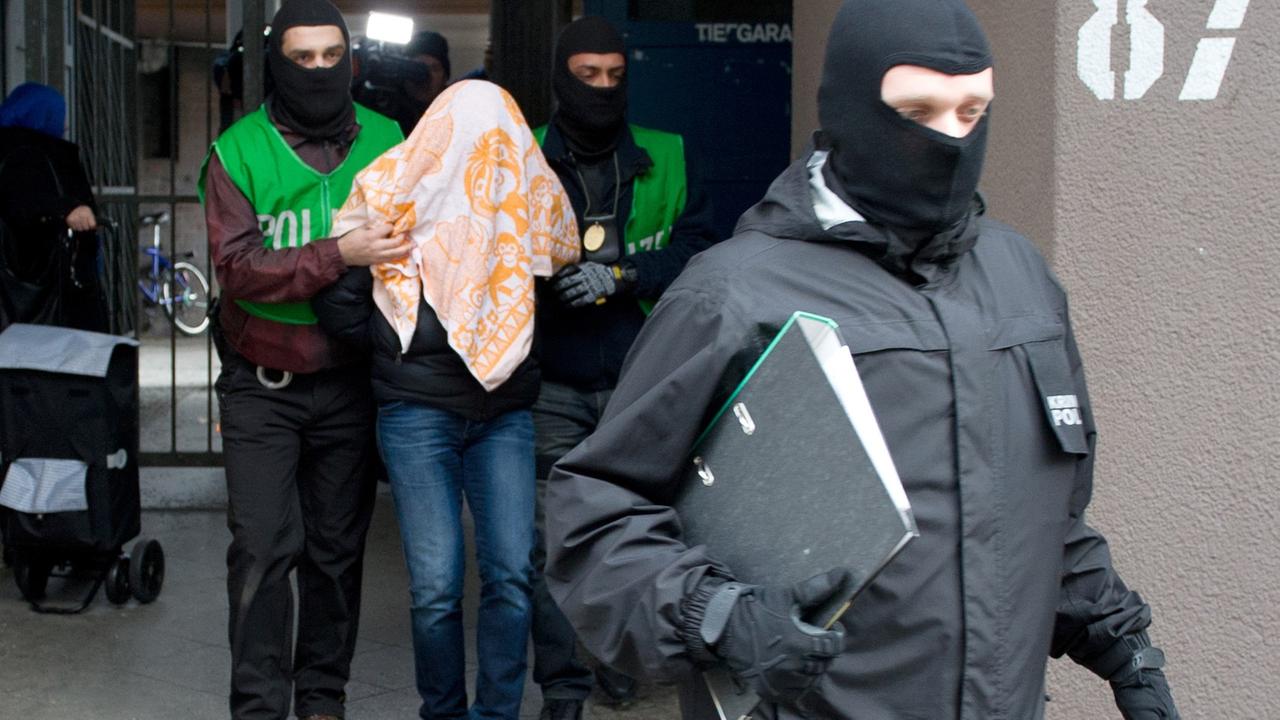 Polizisten führen bei einer Razzia gegen Islamisten am 04.02.2016 in Berlin einen mit einem Tuch verdeckten Verdächtigen ab. Bei Razzien in mehreren Bundesländern hat die Polizei mehrere Islamisten festgenommen, die ein Attentat in Deutschland oder im europäischen Ausland geplant haben sollen Polizisten führen bei einer Razzia gegen Islamisten am 04.02.2016 in Berlin einen mit einem Tuch verdeckten Verdächtigen ab. Bei Razzien in mehreren Bundesländern hat die Polizei mehrere Islamisten festgenommen, die ein Attentat in Deutschland oder im europäischen Ausland geplant haben sollen