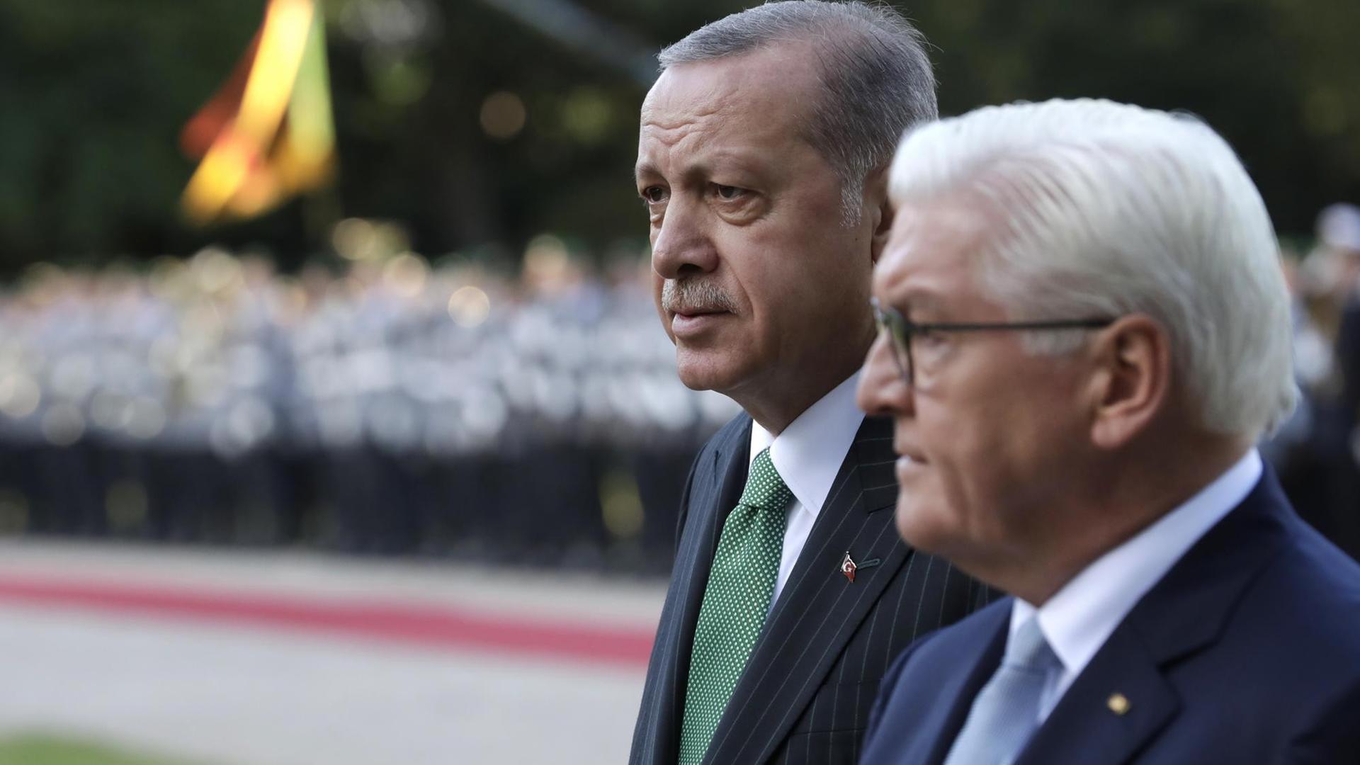 Der türkische Präsident Erdogan und Bundespräsident Steinmeier stehen nebeneinander und nehmen die Ehrenformation der Bundeswehr ab. Der türkische Präsident Erdogan und Bundespräsident Steinmeier stehen nebeneinander und nehmen die Ehrenformation der Bundeswehr ab.