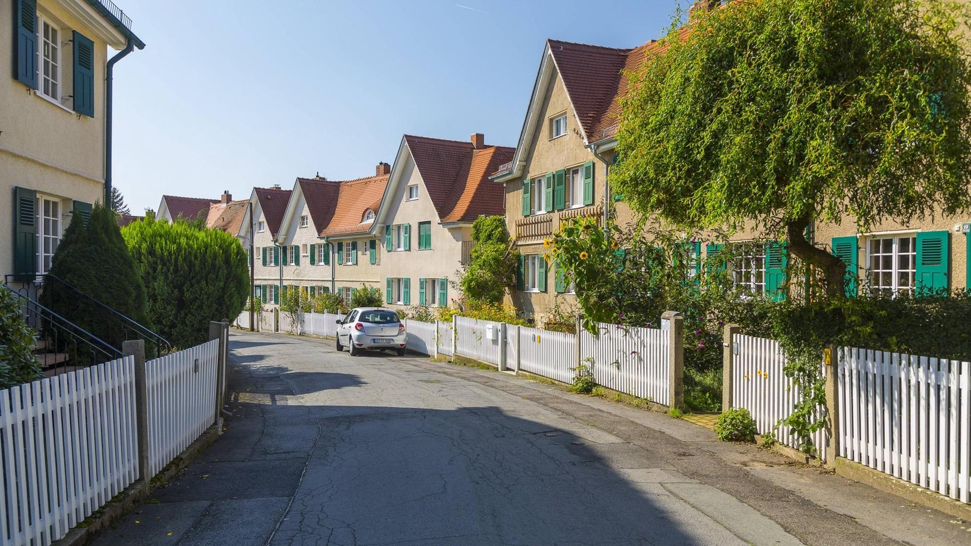 Eine Straße in der Gartenstadt Hellerau in Dresden. Gelb gestrichene Häuser mit grünen Türen und Fensterläden. Eine Straße in der Gartenstadt Hellerau in Dresden. Gelb gestrichene Häuser mit grünen Türen und Fensterläden.