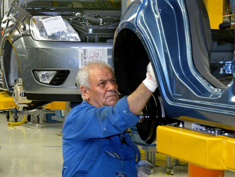 Ein älterer Arbeitnehmer im Ford-Werk in Köln bei der Auto-Montage. Ein älterer Arbeitnehmer im Ford-Werk in Köln bei der Auto-Montage.
