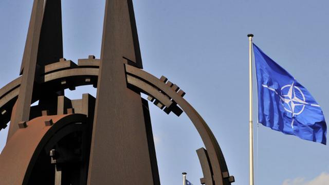Skulptur und Flagge vor dem NATO-Hauptquartier in Brüssel.