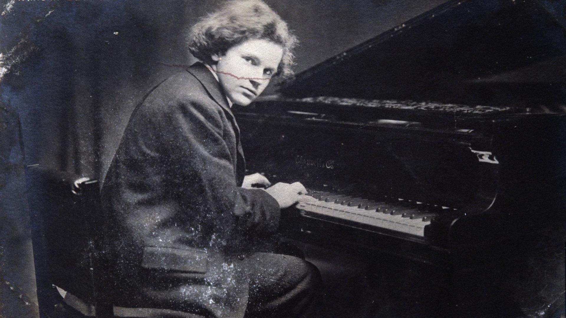 Der junge Pianist Wilhelm Backhaus sitzt am Klavier und spielt. Er schaut in die Kamera. Schwarz-Weiß Fotografie Der junge Pianist Wilhelm Backhaus sitzt am Klavier und spielt. Er schaut in die Kamera. Schwarz-Weiß Fotografie