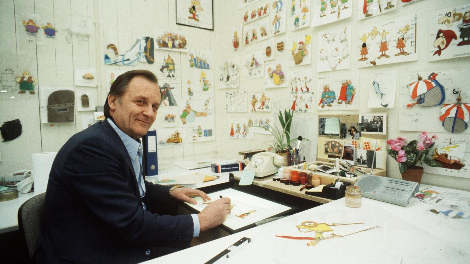 Albert Uderzo sitzt an seinem Schreibtisch und zeichnet, auf dem Tisch einige unfertige Zeichnungen, in den Idefix-Zeichentrick-Studios Paris 1986. Albert Uderzo sitzt an seinem Schreibtisch und zeichnet, auf dem Tisch einige unfertige Zeichnungen, in den Idefix-Zeichentrick-Studios Paris 1986.